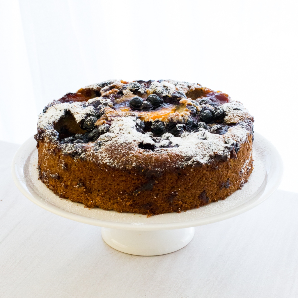 Peach Tea Cake decorated with peaches and blueberries.